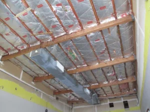 Exposed ceiling joists, foil insulation and ductwork during a church remodel in Ferndale.