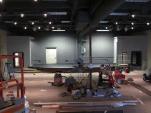 A church auditorium under construction, with a raised stage and tools and lumber scattered across the floor during a Ferndale