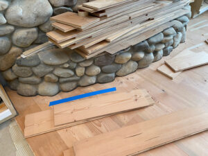installing engineered plank fir flooring scribed to river rock fireplace